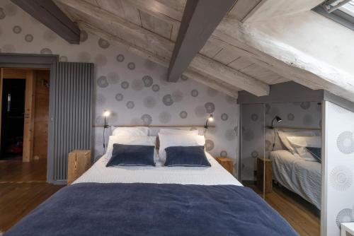 um quarto com uma cama grande e 2 almofadas azuis em Chalet Hygge avec piscine em Saint-Gervais-les-Bains