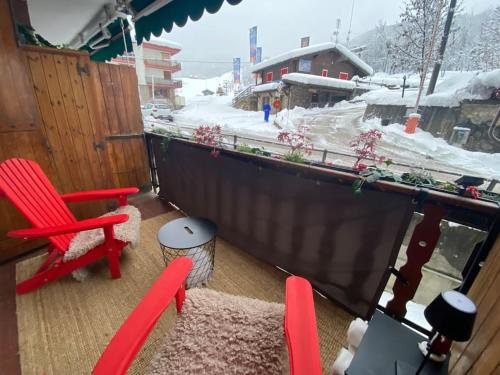 a balcony with a red chair and a table at Little Canadian Lodge, Limone in Limone Piemonte