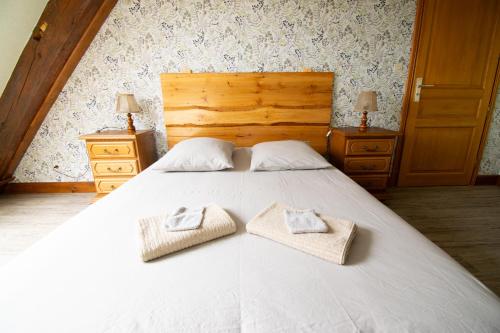 a bedroom with a large white bed with two towels at Le Refuge des Merelles. (accepte les animaux) in Lapoutroie