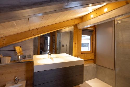 y baño con lavabo y ducha. en Chalet Hygge avec piscine en Saint-Gervais-les-Bains