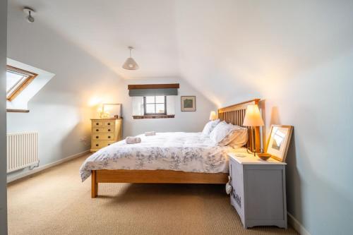 a bedroom with a bed and a lamp on a table at Oyster Barn in Titchwell