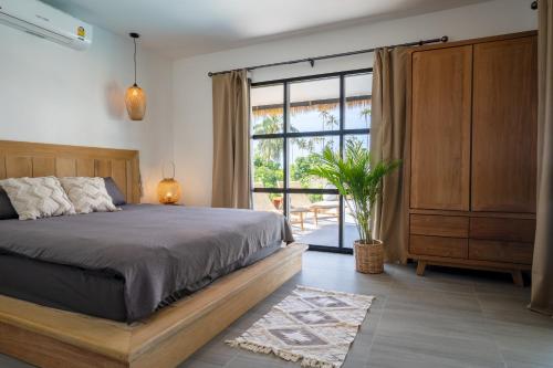 a bedroom with a bed and a large window at Luxury Beachhouse Manao Villas in Ko Lanta