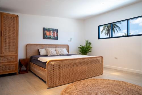 a bedroom with a large bed and two windows at Luxury Beachhouse Manao Villas in Ko Lanta