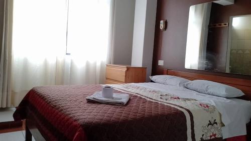 Un dormitorio con una cama con una vela. en hostal nazly, en Chachapoyas