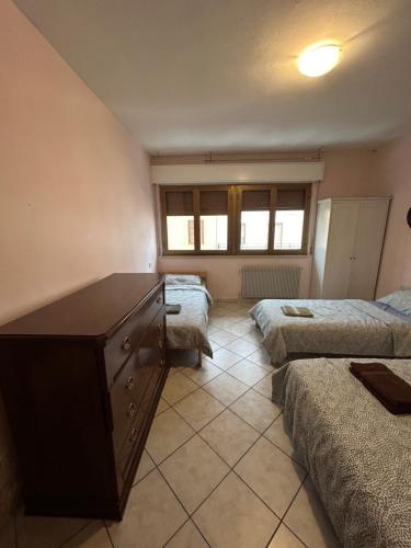 a bedroom with two beds and a dresser in it at Villesse Appartamenti in Villesse