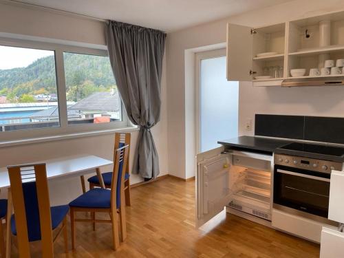 kuchnia ze stołem, stołem i oknem w obiekcie Appartement Emat 13 w mieście Telfs