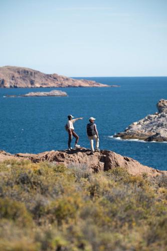 two people standing on a rock near the ocean at Isla Leones Camps in Camarones