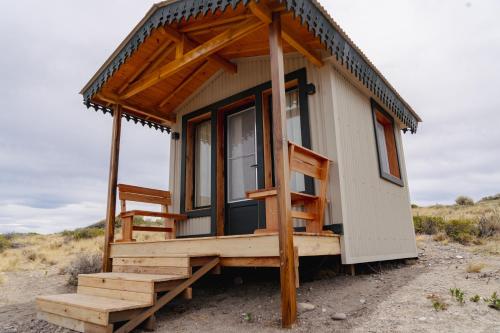 a tiny house with a porch in the desert at Isla Leones Camps in Camarones