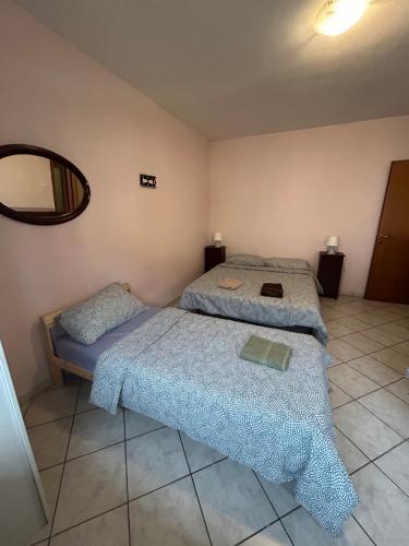 1 dormitorio con 2 camas y espejo en Villesse Appartamenti, 