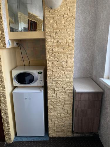 Il comprend une petite cuisine équipée d'un four micro-ondes et d'un réfrigérateur. dans l'établissement One Room Apartment, à Chişinău