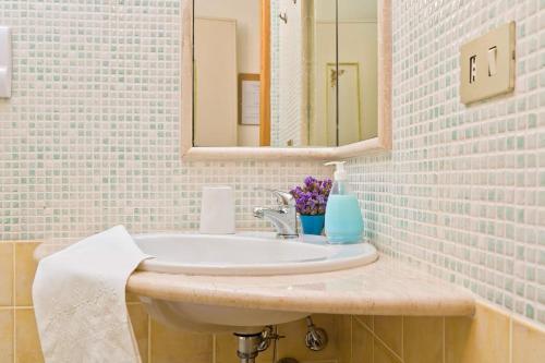une salle de bain avec un lavabo et un miroir dans l'établissement Domo Janas GuestHouse, à Olbia