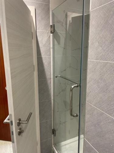 a shower with a glass door in a bathroom at Budget Central Serviced Studio Apartment in Sunderland