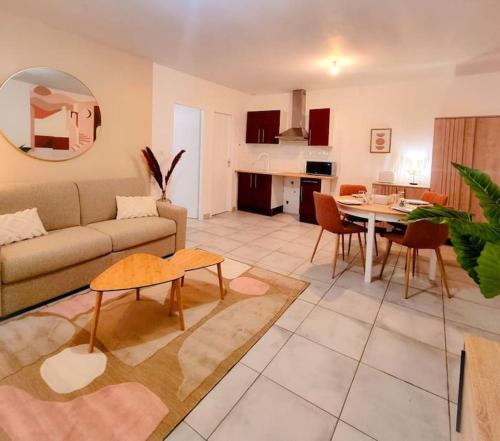 ein Wohnzimmer mit einem Sofa und einem Tisch in der Unterkunft Chez Augustin T2 cosy in Montauban