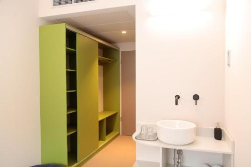 a bathroom with green and white cabinets and a sink at Maverick Central Market in Budapest
