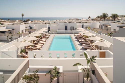 an aerial view of a resort with a pool and umbrellas at Nazaret Beach - Adults only in Arrecife
