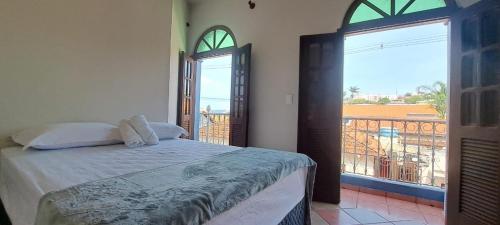 a bedroom with a bed and a balcony at Pousada Economic Pitangui in Pitangui
