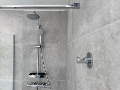 a shower with a shower head in a bathroom at The Pontcanna Sapphire 2-Bed Haven in Cardiff