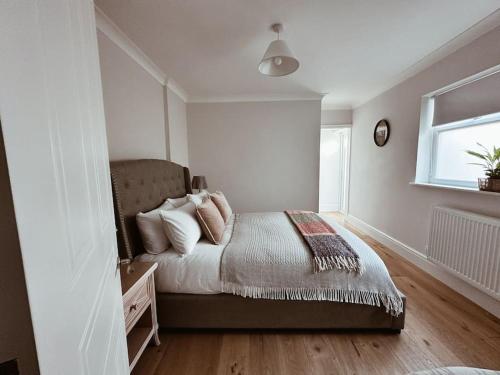 a bedroom with a bed with pillows and a window at The Pontcanna Sapphire 2-Bed Haven in Cardiff