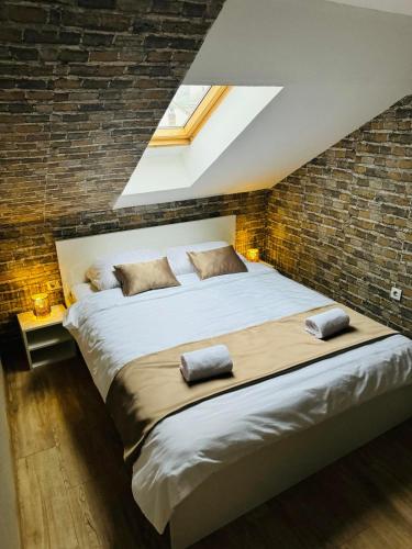 a bedroom with a large bed in a brick wall at Apartment Oscar in Sarajevo