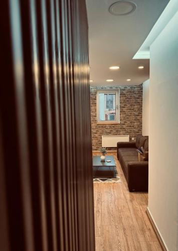 a living room with a couch and a brick wall at Apartment Oscar in Sarajevo