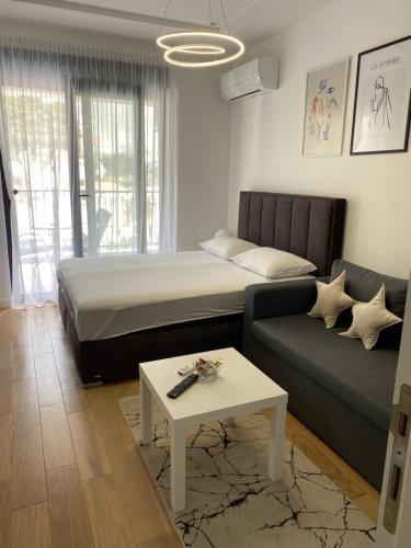 a living room with a bed and a couch at Apartman PORTO in Trebinje