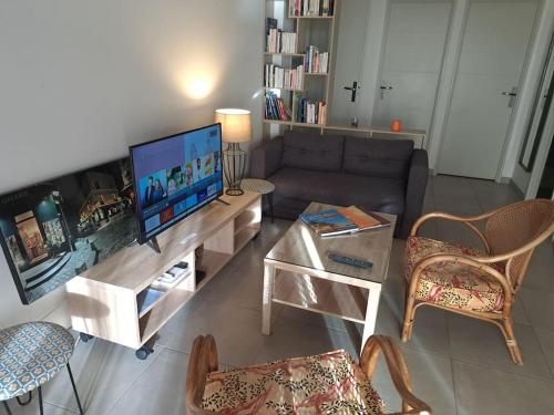 sala de estar con sofá y TV en T3- vue mer - Plage 50 m, en Martigues