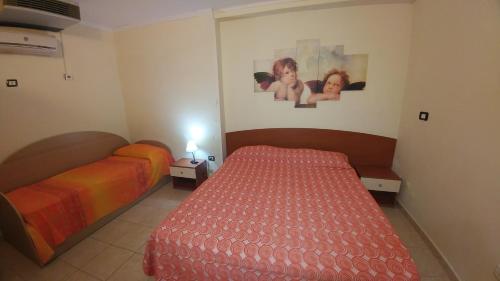 um quarto com duas camas e duas fotografias na parede em APPARTAMENTO AL MARE CON PISCINA em Rodi Garganico