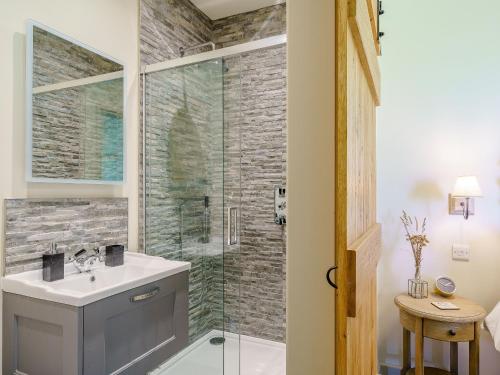 a bathroom with a sink and a glass shower at 1 Pheasant in East Ilsley