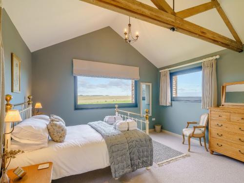 a bedroom with a large bed and a window at 1 Pheasant in East Ilsley