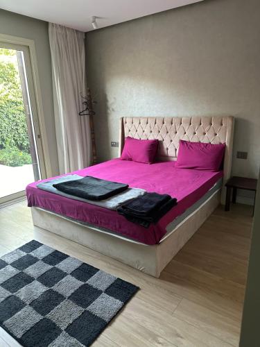 a bedroom with a large pink bed with pink pillows at Oriana Villa Guest House in Cairo