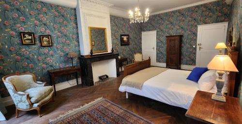 a bedroom with a bed and a chair and a fireplace at La Pelisserie, Chambres d'Hotes in Saint-Antonin-Noble-Val