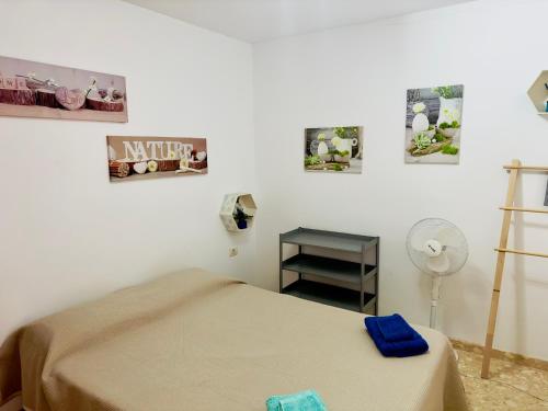 1 dormitorio con 1 cama, ventilador y cuadros en la pared en Oasis Retreat 793 - Appartamento con piscina a Amarilla Golf, en San Miguel de Abona