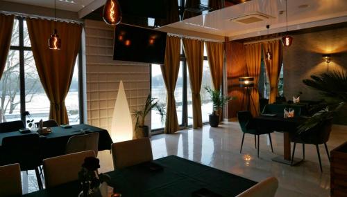 a restaurant with tables and chairs and a large window at Hotel Oskar Business & Spa in Puławy