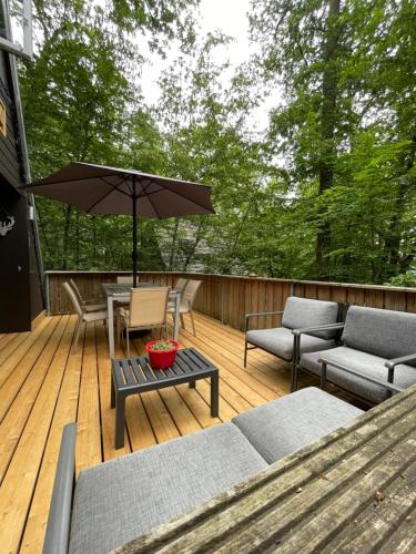 eine Terrasse mit einem Tisch, Stühlen und einem Sonnenschirm in der Unterkunft Chalet la Catrina - Bungalow 41, Sunclass Durbuy in Durbuy