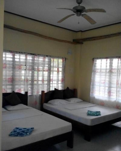 圣维森特Ayette's Bamboo Cottages的一间带两张床和吊扇的卧室