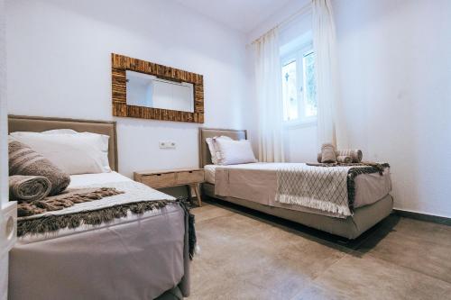 a bedroom with two beds and a mirror on the wall at Luxury Apartments La Villa in Chorto