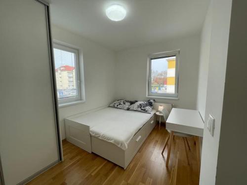 Dormitorio pequeño con cama y espejo en Trojizbový byt vzdialený 800 m od X bionic Shere s dvoma kúpeľňami, en Šamorín