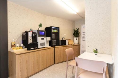 a room with a counter with a microwave and a table and chairs at No 25 Hotel Dongam Branch in Incheon