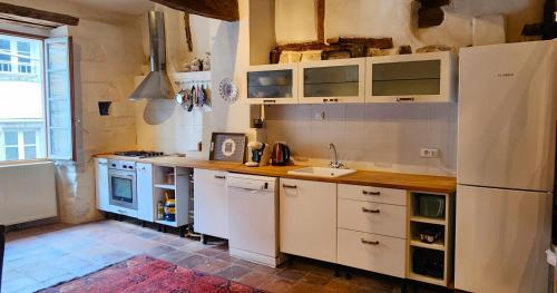 a kitchen with white cabinets and a sink at La Pelisserie, Chambres d'Hotes in Saint-Antonin-Noble-Val