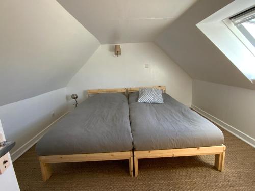 um quarto com uma cama no sótão em Maison à 500m de la plage em Plogoff