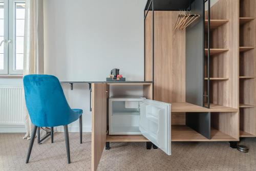 a desk and a blue chair in a room at Przystań Jeziorany - willa nad jeziorem - Warmia i Mazury in Jeziorany