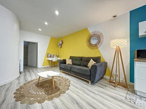 un salon avec un canapé et une table dans l'établissement Confort, wifi et garage, à Millau