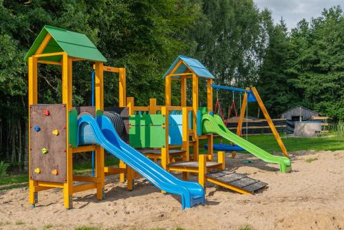 a playground with a slide in the sand at Przystań Jeziorany - willa nad jeziorem - Warmia i Mazury in Jeziorany