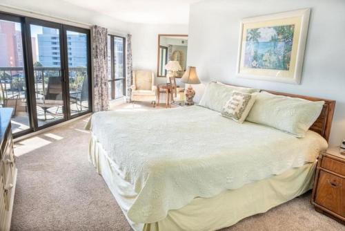 a bedroom with a large bed and a balcony at Carol Bay 503 in Myrtle Beach