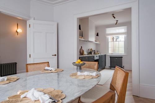 een keuken en eetkamer met een tafel en stoelen bij The Nomad House - Sea Views Overlooking the Square in Ramsgate