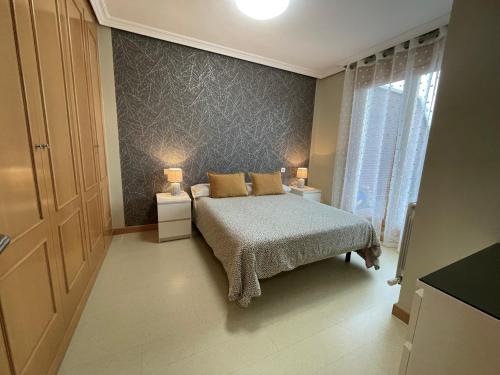 1 dormitorio con 1 cama, 2 mesitas de noche y ventana en Apartamento con gran terraza y vistas a la catedral., en Burgos