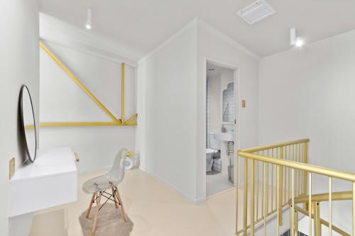 a white hallway with a chair and a bathroom at Loft on Hope in Cape Town