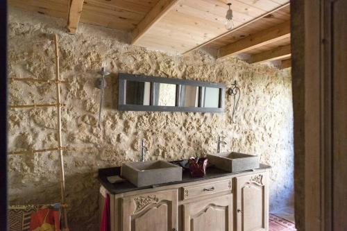 ein Badezimmer mit zwei Waschbecken an einer Steinmauer in der Unterkunft Ancien moulin atypique proche de Toulouse in Lavaur