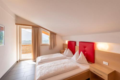 a bedroom with two beds and a large window at Der Blaue Reiter in Schenna