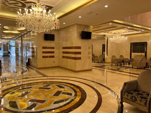 hol z żyrandolem i duży pokój z krzesłami w obiekcie فندق بنيان العزيزية w Mekce